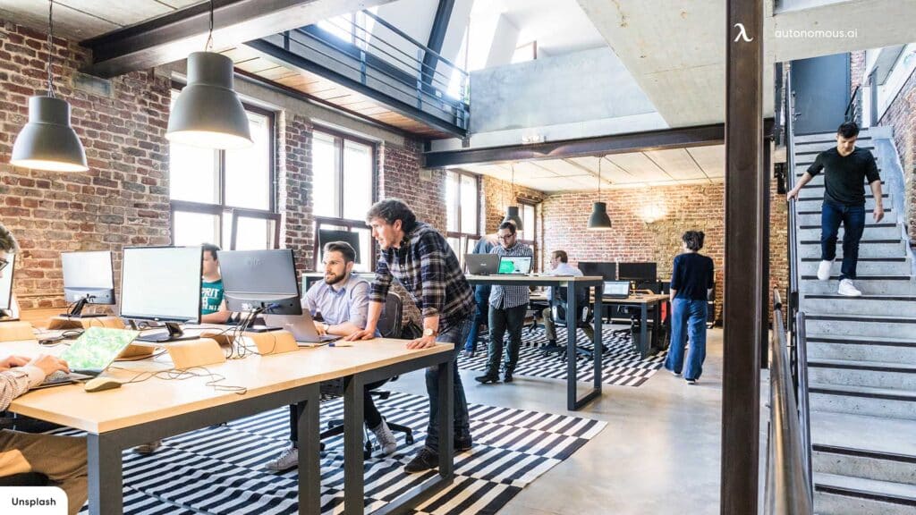 modern industrial office with people working over there sitting on tables with their systems