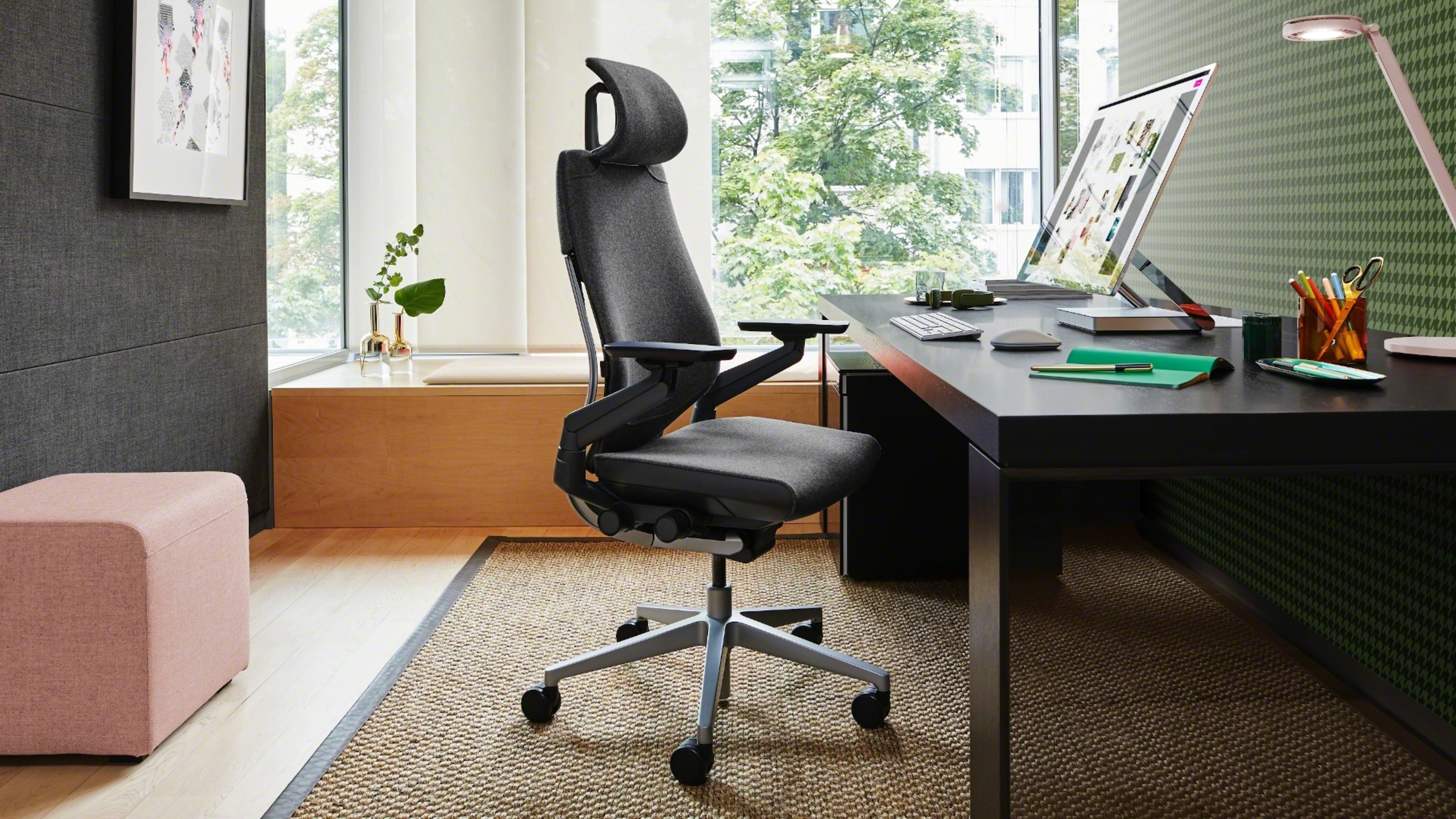 a comfy chair wokring desk and pc placed on desk a stool