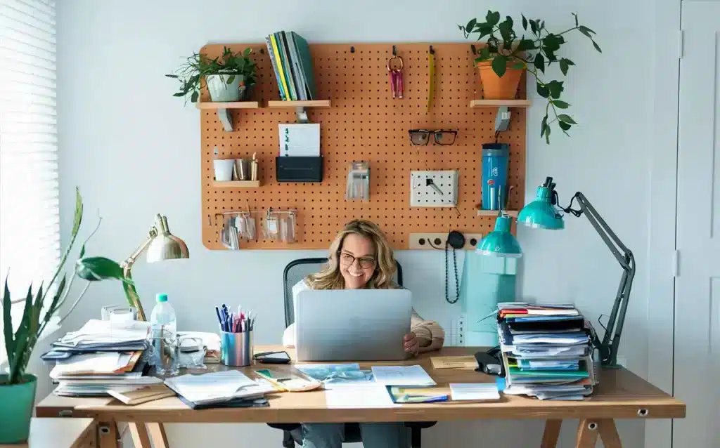 a woman sitting on a chair in home office spacxe with laptop files placed on table floating shelves