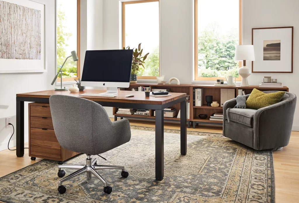 contemporary home office with a wokring chair desk comfy sofa and large windows