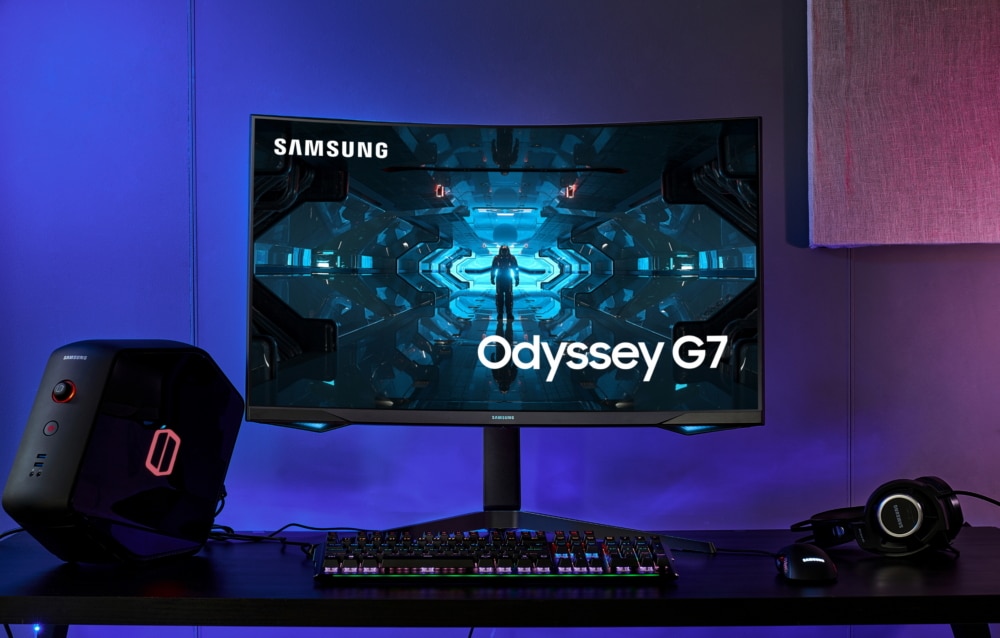 samsung odyssey monitor wirh a keyboard headphones and sound system