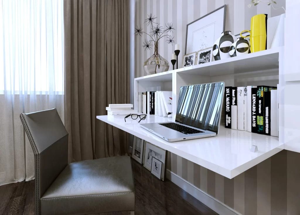 smart multifunctional chair placed in front of a wokring desk laptop on the desk with books and art work on upper shelf