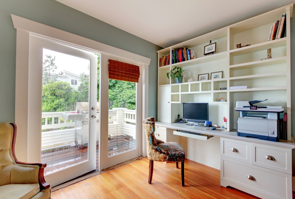 Home Office With White Open Shelves Hardwood Floor And Blue walls