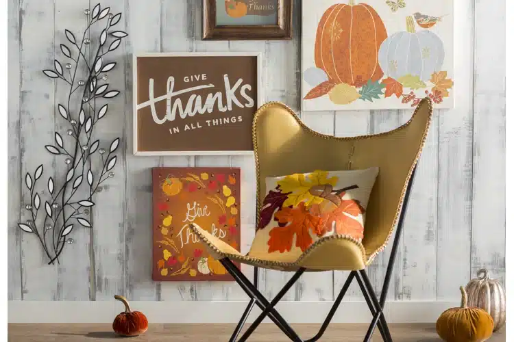 a chair wirh a fall themed pillow pumpkins on floor fall art work on floor