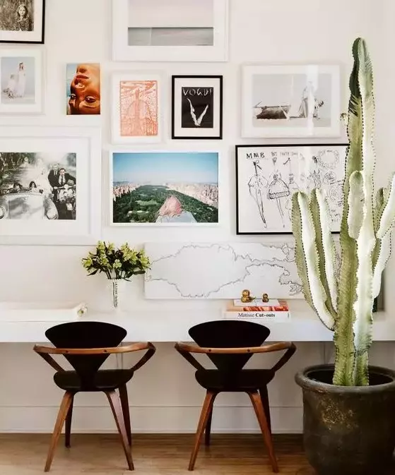 autumnal gallery wall with lots of paintings chairs and a plant