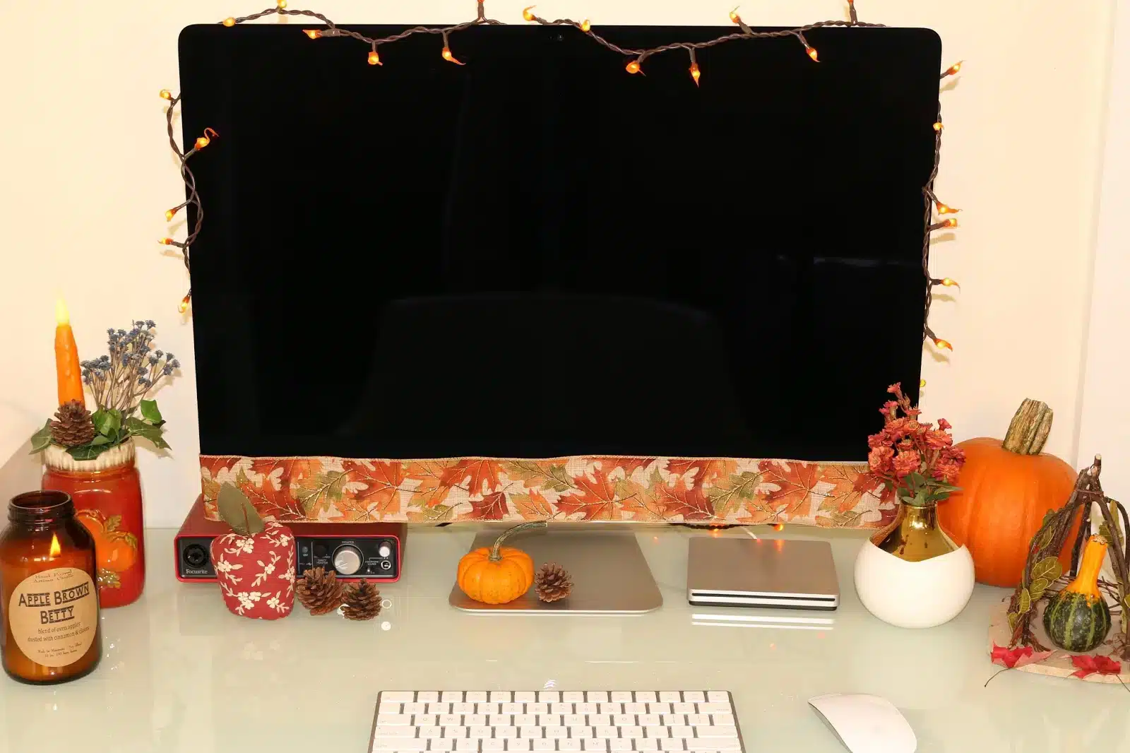 fall themed desk monitor with string lighting keyboard fall themed pen holder pumpkin