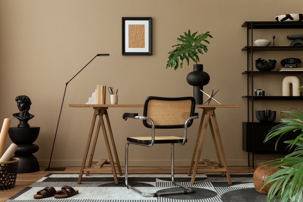 home office with a smart chair, black sculptures, floating shelves, pots, and a geometric rug