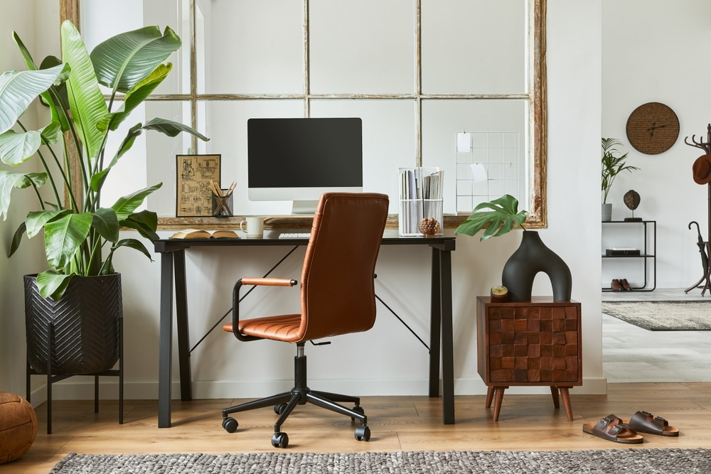 home office workspace interior design with black industrial desk, brown leather armchair