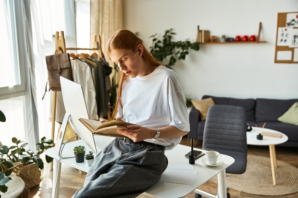 Engrossed in a book, a young person enjoys a peaceful moment in home office nook