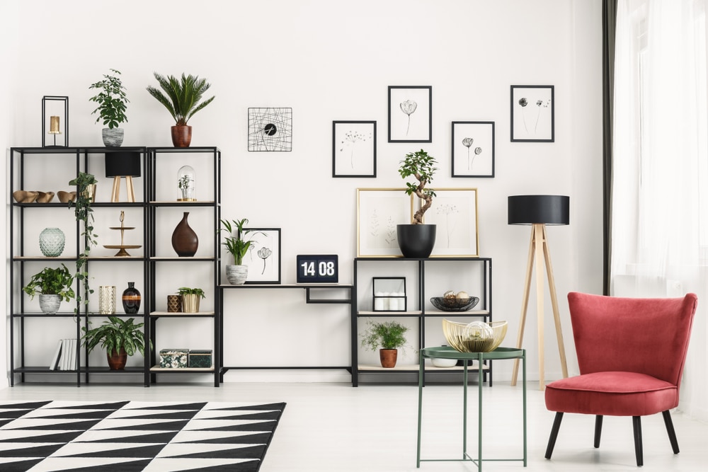 Red armchair standing in a white, industrial room interior with gallery on the wall