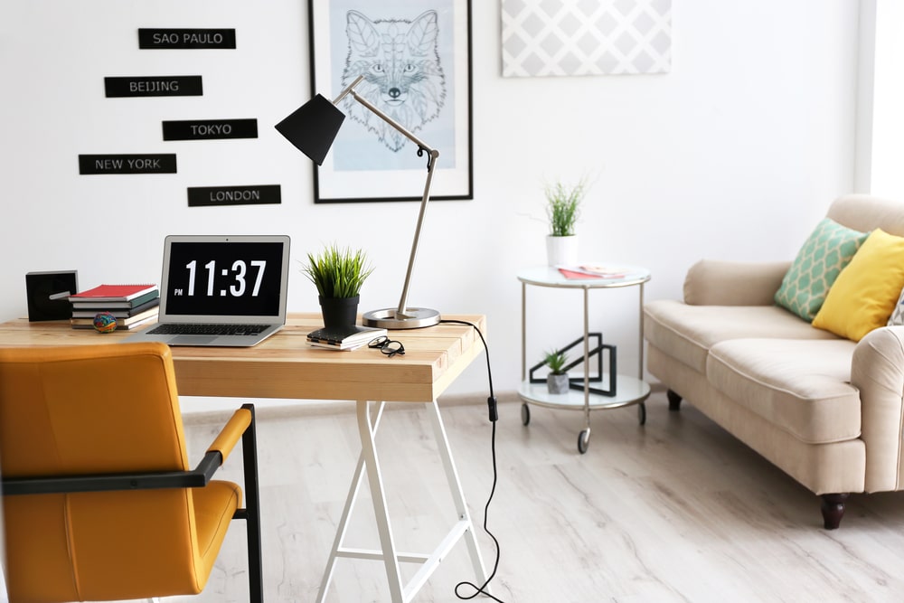 colorful pillows on couch, working chair, lamp in home office space