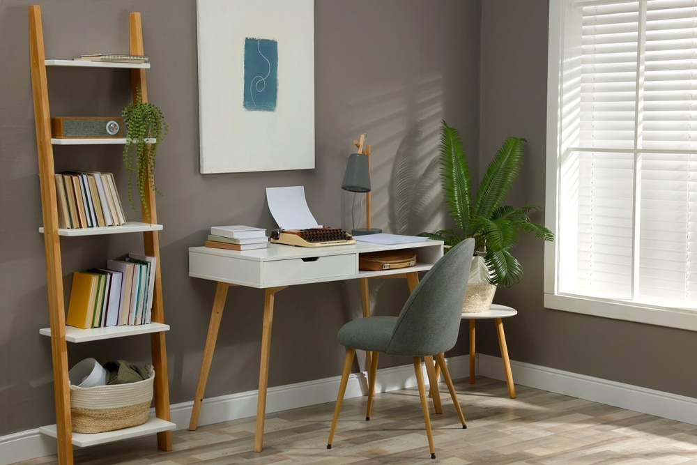 stylish chair in a home office space with art on wall, plant on side, books in rack